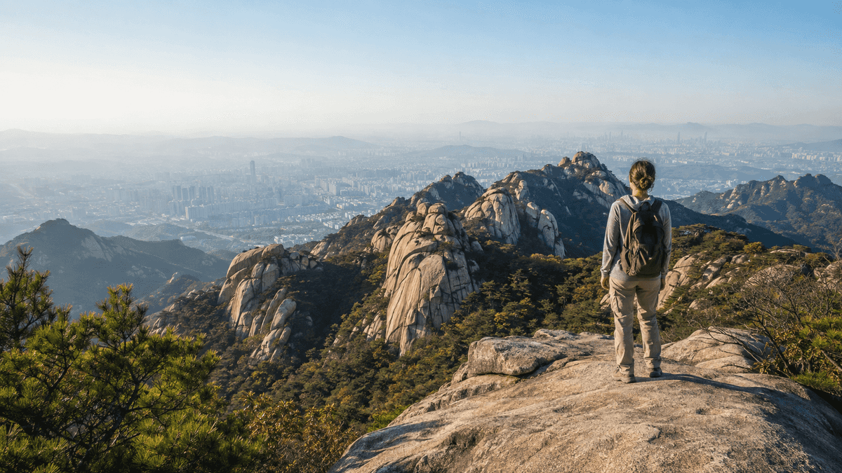 A traveler looking across the granite peaks of Bukhansan and the Seoul skyline